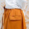 Side pocket on orange cotton trousers