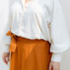 Plus size woman wearing orange cotton skirt and beige shirt