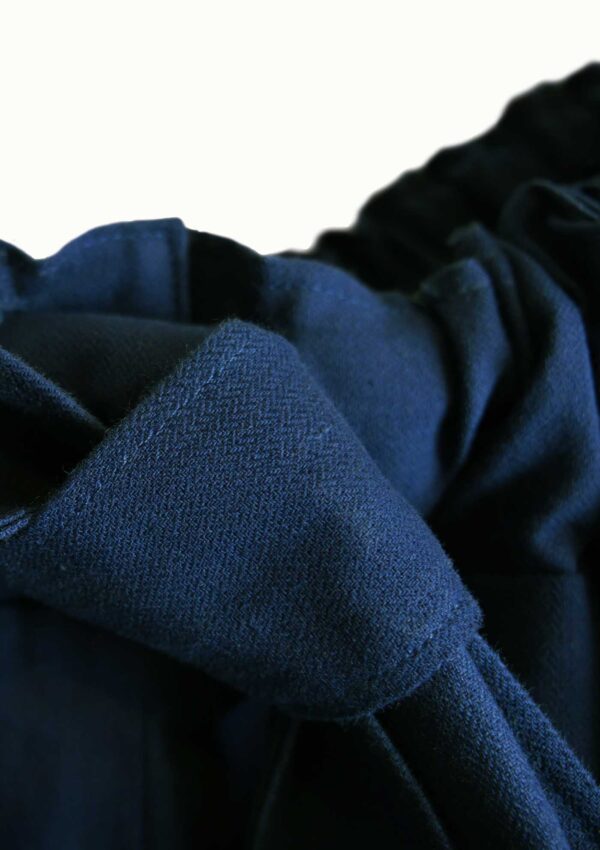 Detail of oversized dark blue trousers made from sustainable cotton